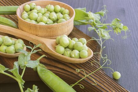 young fresh green peas on a wooden Board. new cropの写真素材
