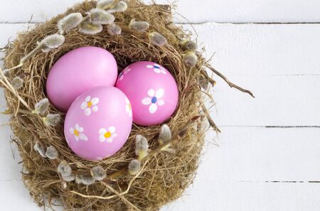 pink  painted Easter eggs on a wooden white background