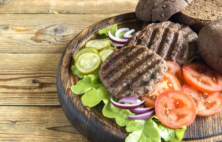 ingredients for a homemade Burger on a wooden Boardの写真素材