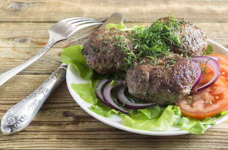 fried homemade cutlets on a white plateの写真素材