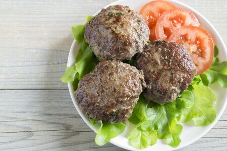 fried homemade cutlets on a white plateの写真素材