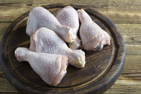 raw chicken legs on a wooden Board.の写真素材