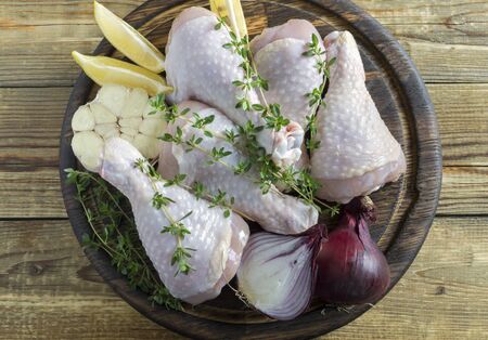 raw chicken legs on a wooden Board.の写真素材
