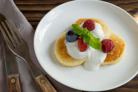 Cottage cheese pancakes, syrniki with fresh berries for breakfastの写真素材
