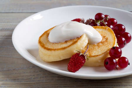 Cottage cheese pancakes, syrniki with fresh berries for breakfastの写真素材