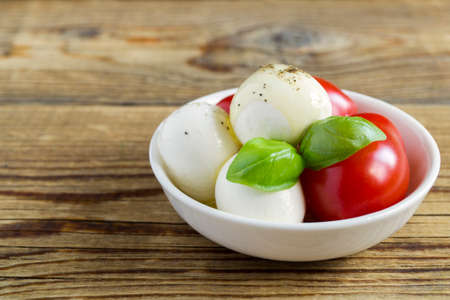 Caprese salad with ripe tomatoes and mozzarella with fresh Basil leaves. Italian food.