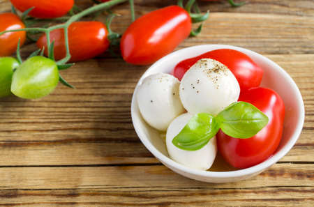Caprese salad with ripe tomatoes and mozzarella with fresh Basil leaves. Italian food.の写真素材
