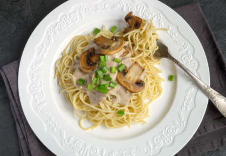 Spaghetti with mushrooms in cream sauce. on dark backgroundの写真素材