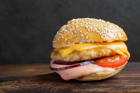fish Burger with sauce and cheese on a wooden table.の写真素材