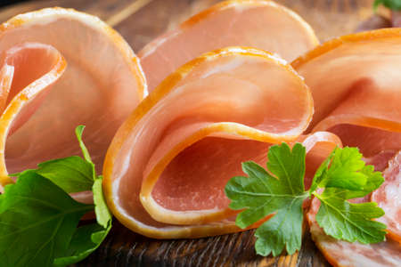Thinly sliced smoked ham on a Board. meat snackの写真素材