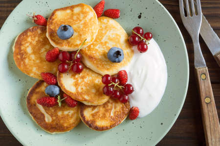 Cottage cheese pancakes, syrniki with fresh berries for breakfastの写真素材