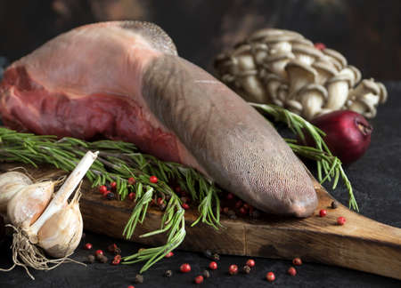 raw beef tongue on a chopping Board. with spicesの写真素材