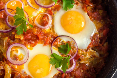 shakshuka, a traditional Israeli dish. Sunny side up egg with stewed tomatoes.