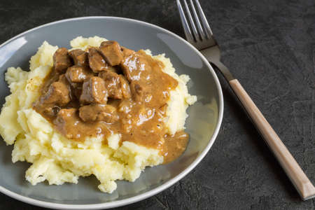 simple home-cooked food. stewed meat in gravy and mashed potatoes.の写真素材