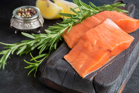 Salmon steak raw fish prepared for cooking. Top view on black table.