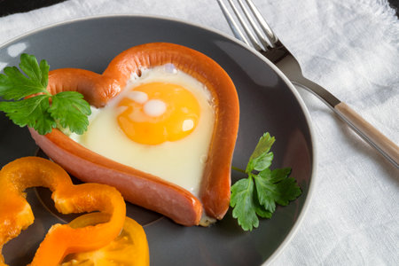 valentine's day breakfast. sausage with scrambled egg in the shape of a heart.の写真素材