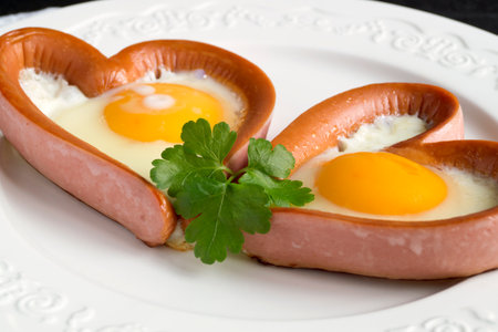 valentine's day breakfast. sausage with scrambled egg in the shape of a heart.の写真素材