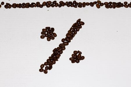 Percent sign from coffee beans laid out on a beige backgroundの写真素材