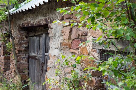 abandoned building of masonry with an old wooden doorの写真素材