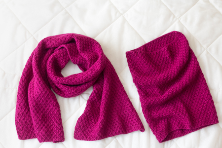 Hat and scarf wine red rag background knitted wool by hand on the spokesの写真素材
