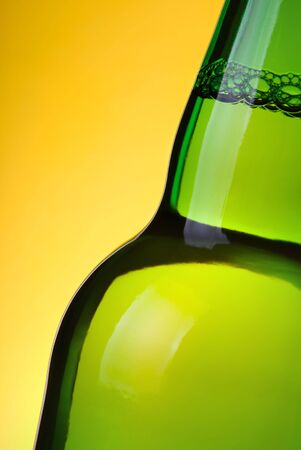 Part of beer bottle on yellow backgroundの写真素材