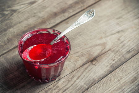 Sweet berry syrup in a cup on a wooden rustic tableの写真素材