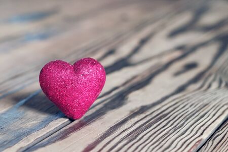 Red heart with glitter on wood. St. Valentine's Day. Shallow DOF, soft focus. の写真素材