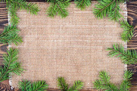 Christmas background with a linen cloth and Christmas tree brancの写真素材