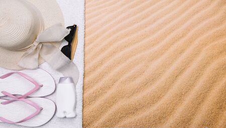 Top view of sandy beach with towel frame and summer accessories. Background with copy space and visible sand texture. left border made of towelの写真素材