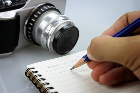Hand and pencil writhing someting on notebookの写真素材