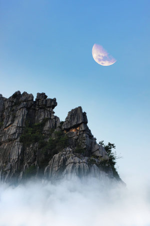 top of mountain, fog, clouds and moonの写真素材