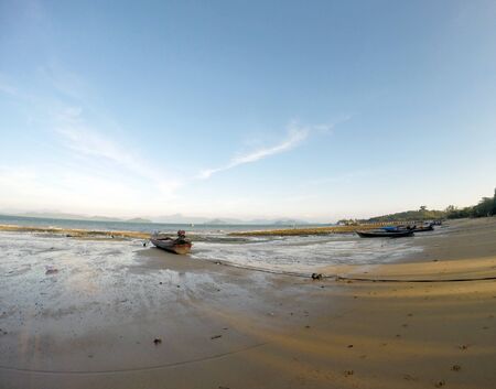 The boat moored on a sandy beach at low tide until dry.view from wide len.の写真素材