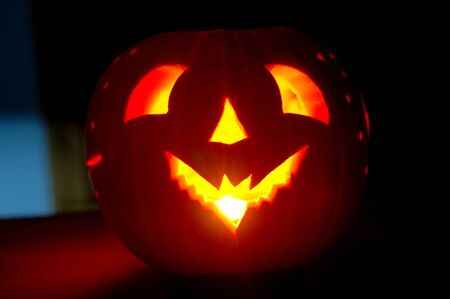 A Jack O Lantern ready for Halloween, glows with it's spooky candle lit faceの写真素材