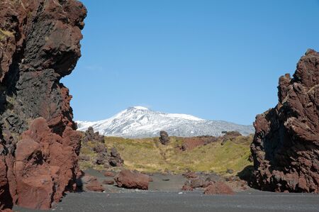 The west of Iceland, at the western end of the peninsula Sneifellsnes, overlooking the volcano Sneifellsjökull, from the black beach of Djupalonssandur の写真素材