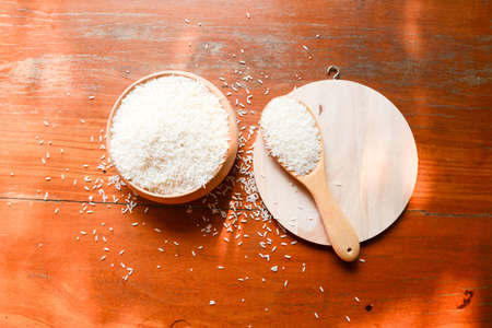 rice in spoon on wooden backgroundの写真素材