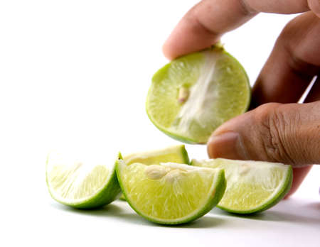 Fresh cut lime quarters  citrus fruit isolated on white background with shadowの写真素材