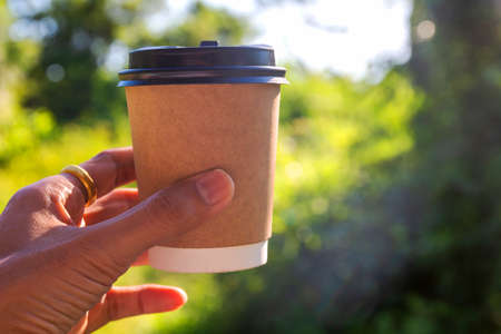 cup of tea in hand, cup of coffee and milkの写真素材