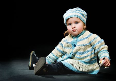 sitting little baby in a bound suit on black background  の写真素材
