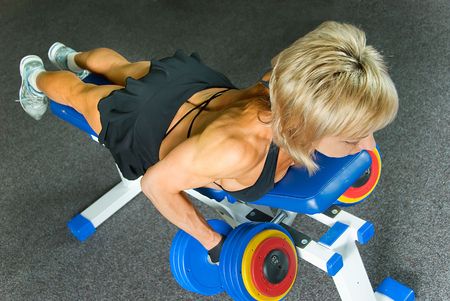 woman bodybuilder does exercise for muscles of back の写真素材