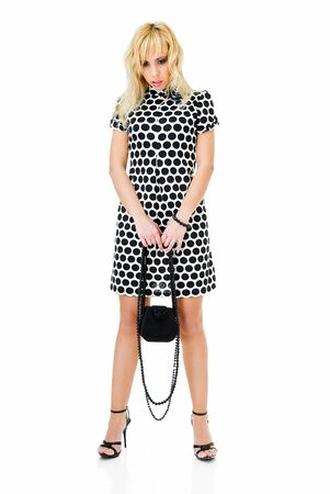 young sad woman in spotted dress on white の写真素材