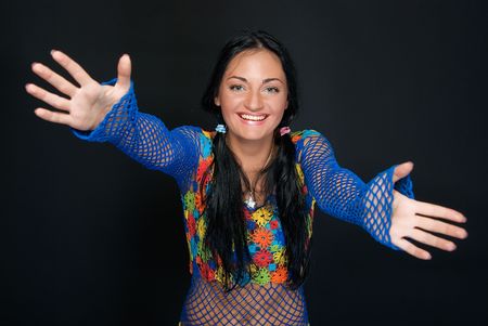 young pretty woman with outstretched arms on blackの写真素材