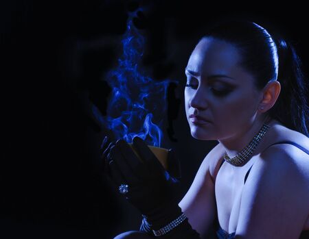 beautiful woman with cup of steaming drink under the moon-lightの写真素材