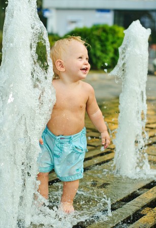 little boy about city fountain at summerの写真素材