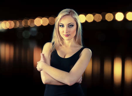 portrait of beauty blonde girl on black background with night lights, a bit effect cross processの写真素材