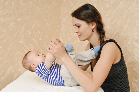 young mother and her baby in the room about wall with wall-paperの写真素材