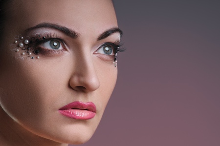 face of beautiful girl with makeup on raspberry grey backgroundの写真素材