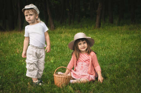little boy and girl on the grass in the forestの写真素材