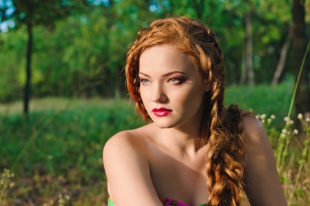 red haired young woman with plait in summerの写真素材