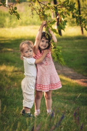little girl and boy in the forest about mulberry treeの写真素材