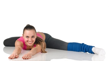 young happy woman does fitness exercise on white background. Smiling and very slim. On the floor. の写真素材